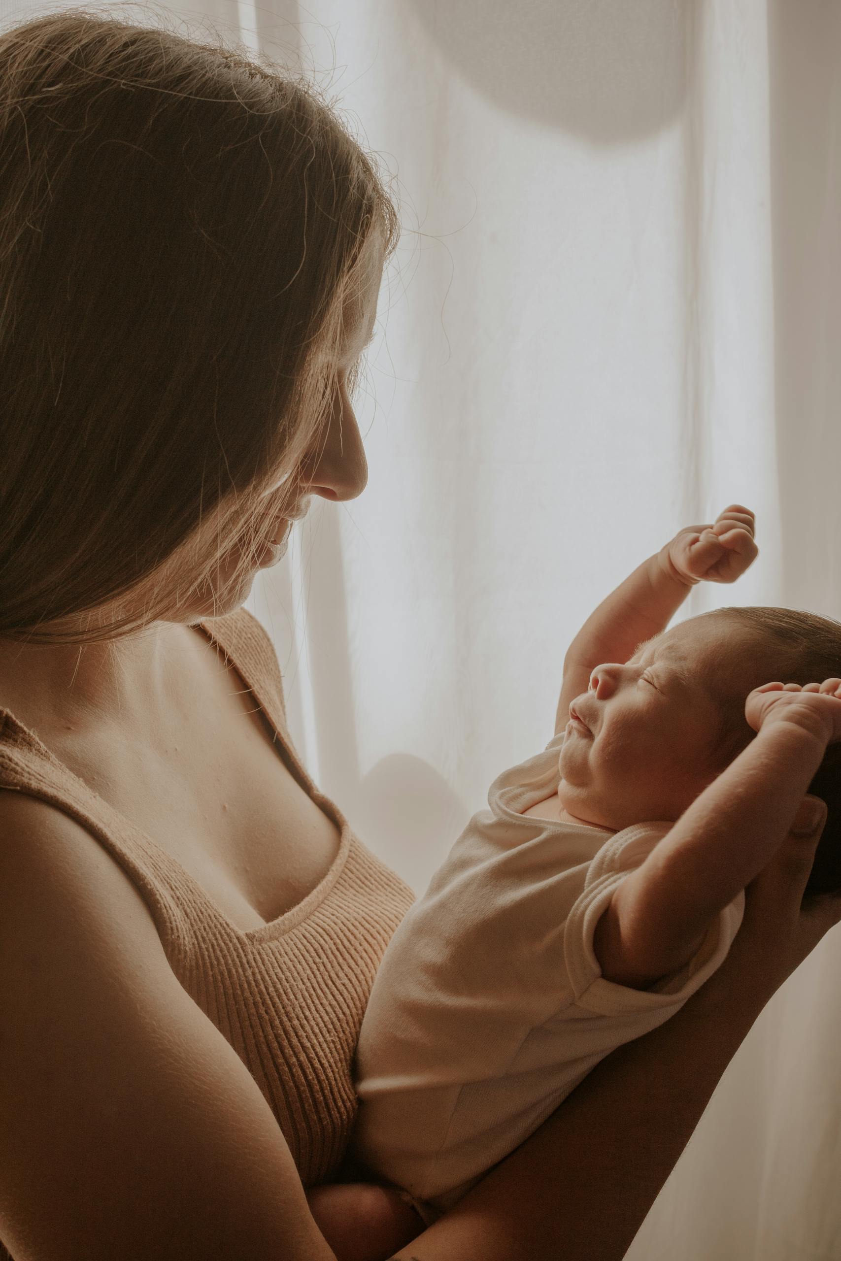 A loving mother holding her newborn baby indoors in São Paulo.